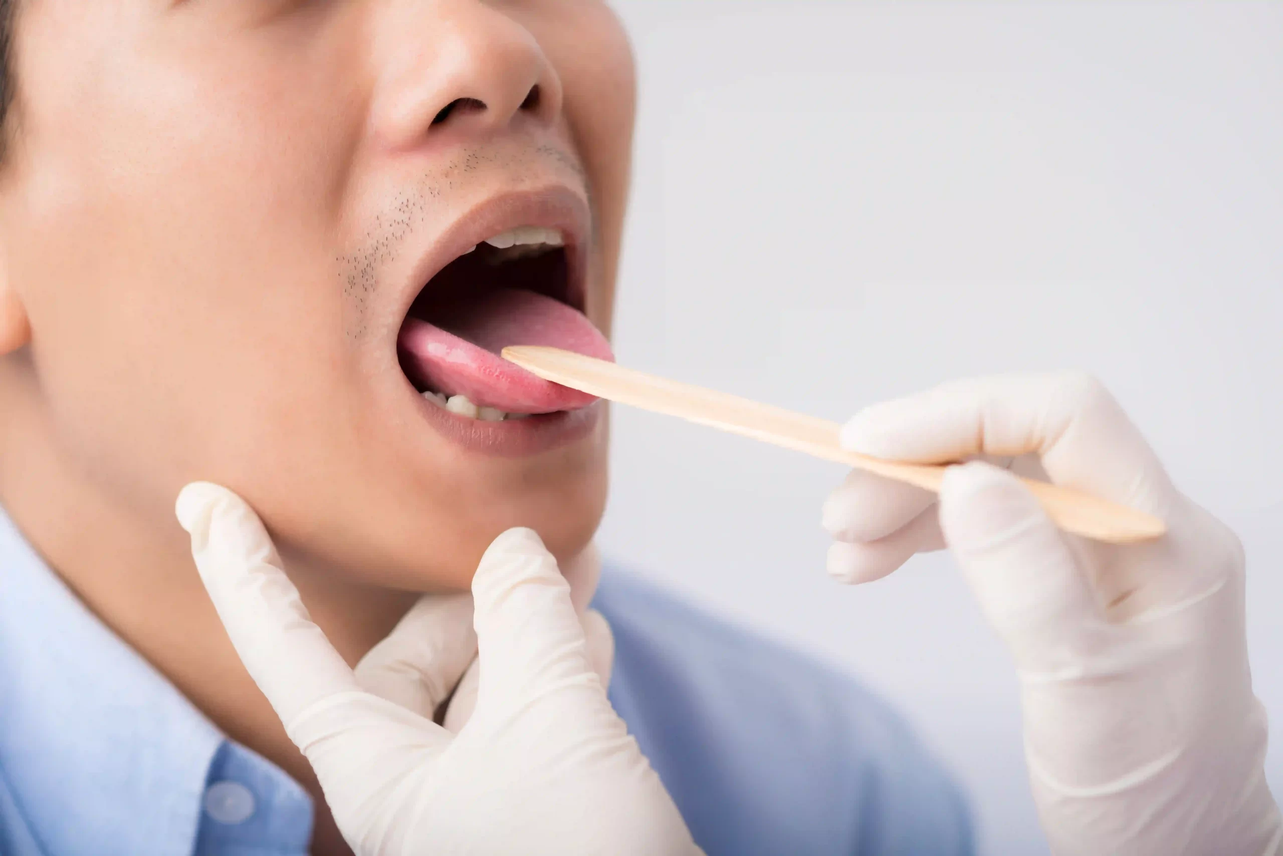ENT specialist examining a patient's throat