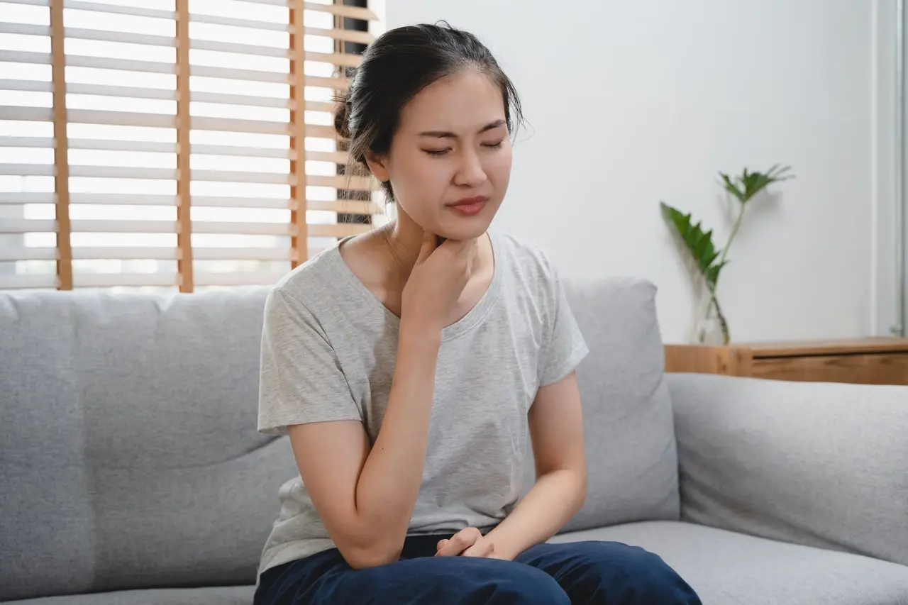 Woman experiencing hoarseness due to silent reflux